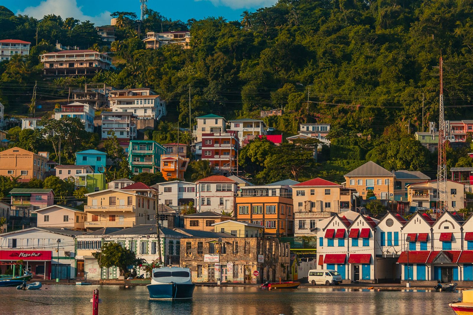 Colorful houses climbing the hillside above the Carenage harbor in St. George&rsquo;s, Grenada