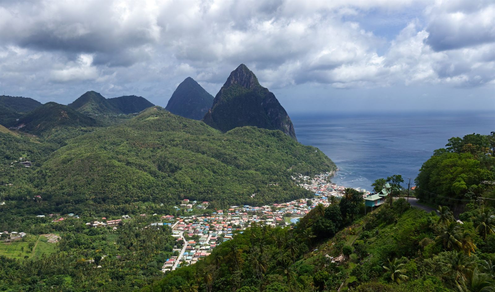 The twin Piton peaks of St. Lucia rising above green hills and the town of Soufriere