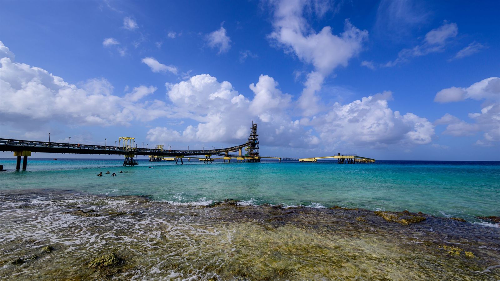 Long pier over clear water on the dry, sunny coast of Bonaire